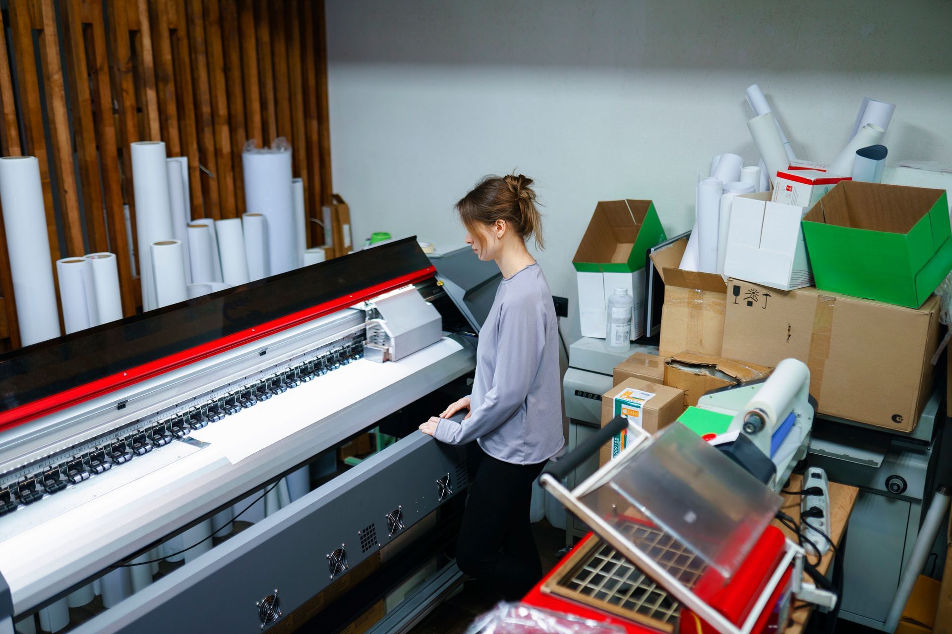 Woman operating machine in printing studio.
