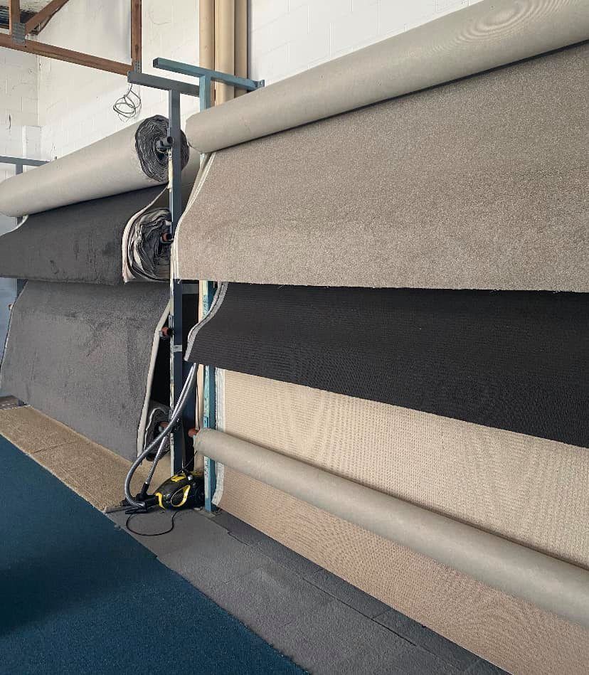 Rolls Of Carpet In Various Colors On Display Racks — Mareeba Floor Covering Centre in Mareeba, QLD