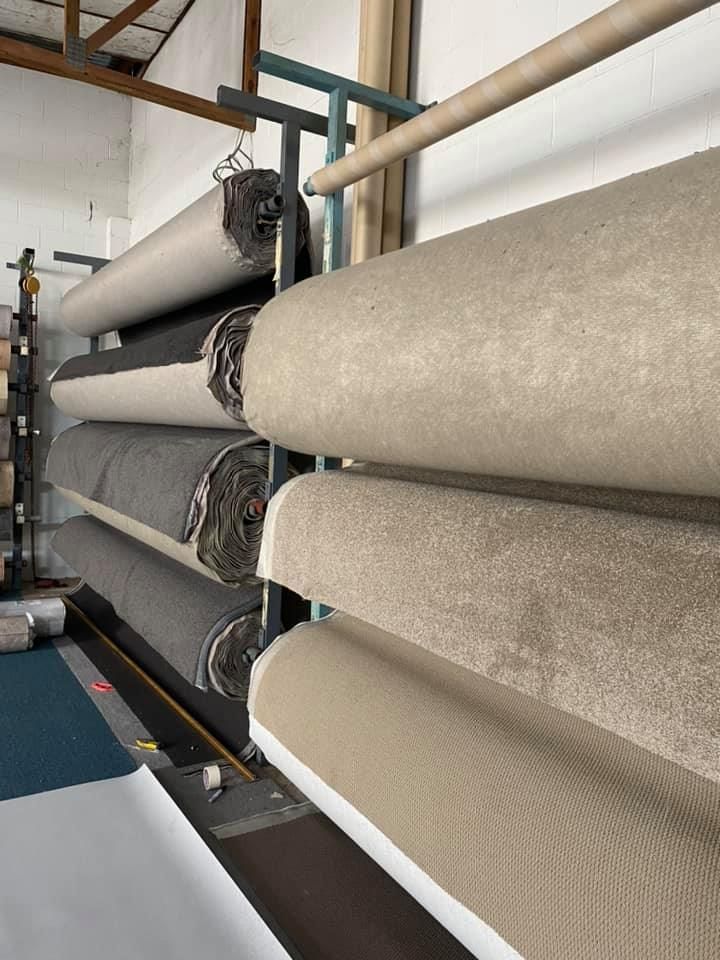 Shelves holding rolls of carpet in various neutral colors — Mareeba Floor Covering Centre in Mareeba, QLD