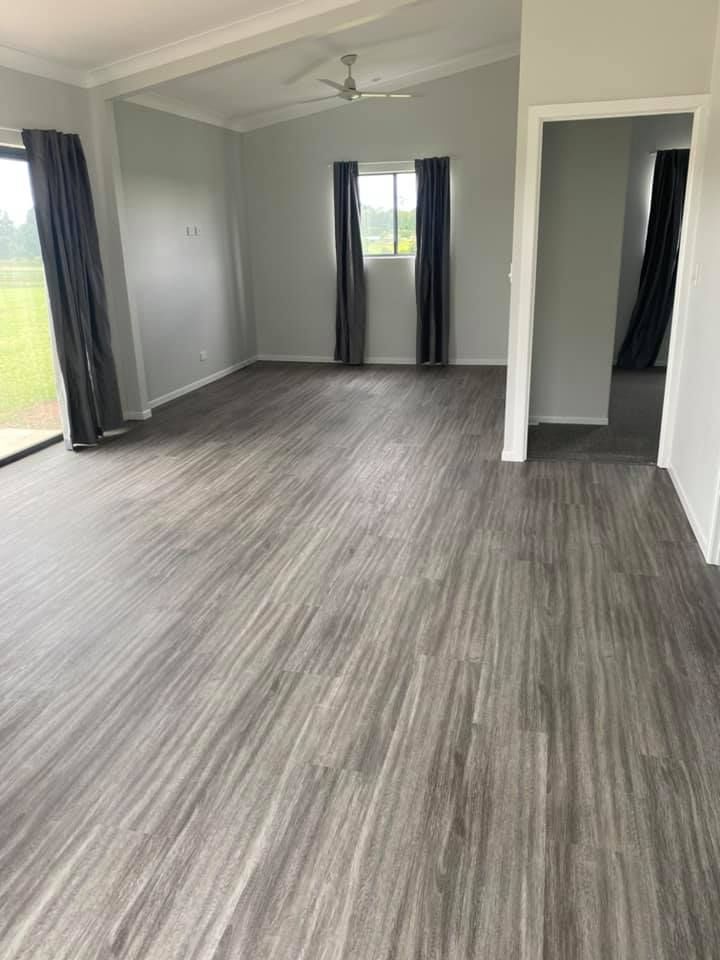 Empty living room with gray wood-look flooring — Mareeba Floor Covering Centre in Mareeba, QLD