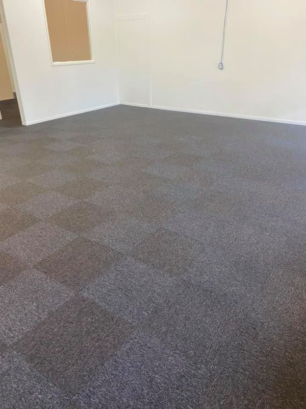 Dark Gray Carpet Tiles In A Room With White Walls — Mareeba Floor Covering Centre in Port Douglas, QLD