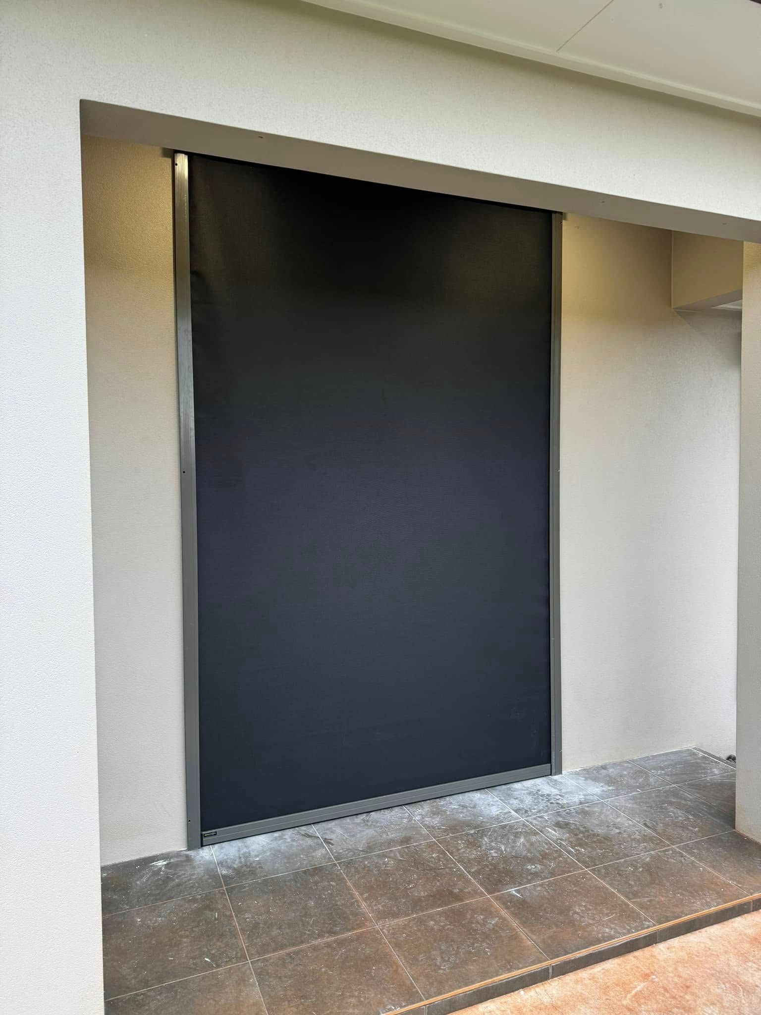 Three Dark Roller Blinds In A Room, With Sunlight Illuminating The Edges — Mareeba Floor Covering Centre in Mareeba, QLD