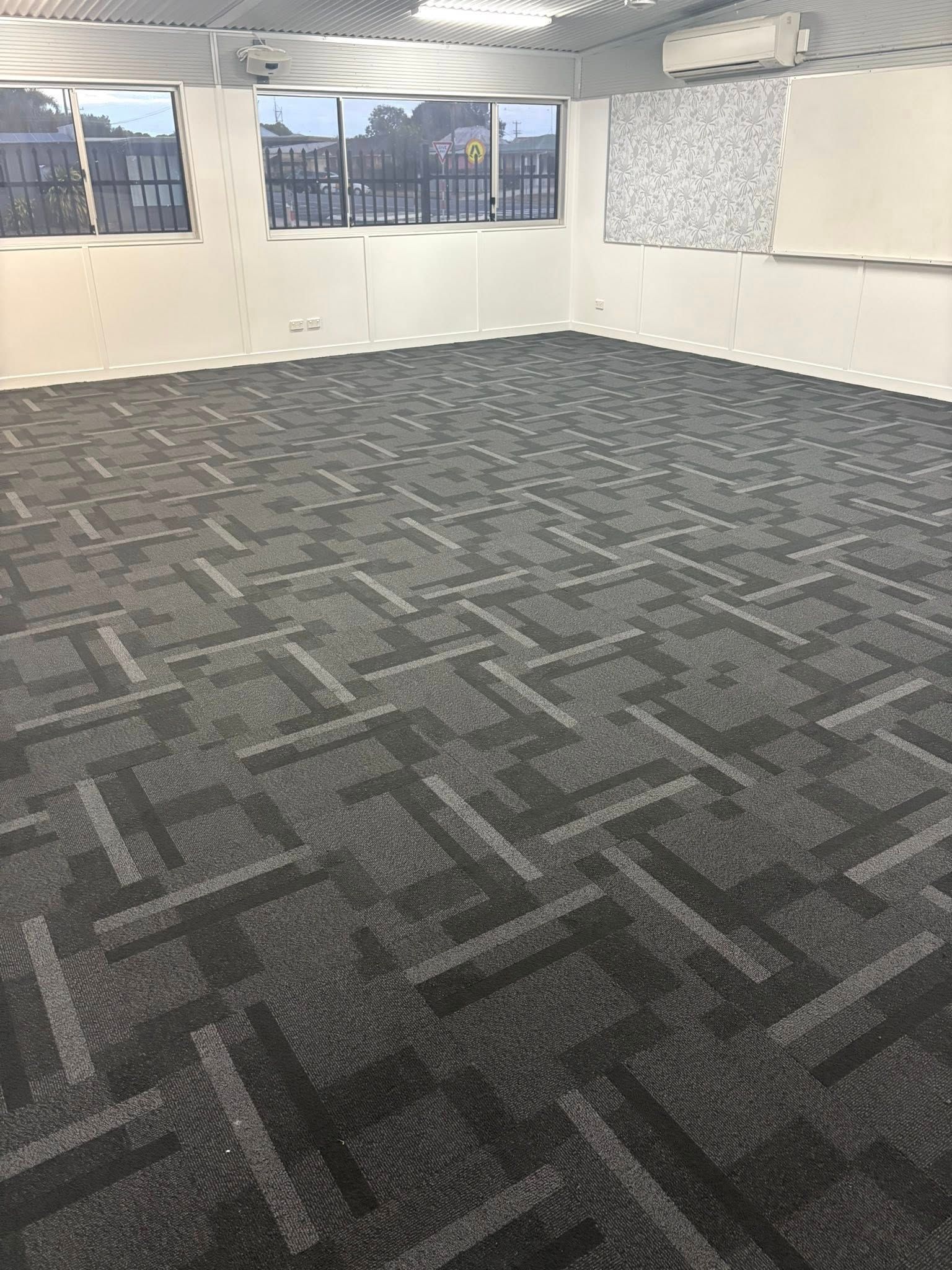 Empty Room With Dark Gray Patterned Carpet And White Walls — Mareeba Floor Covering Centre in Cooktown, QLD