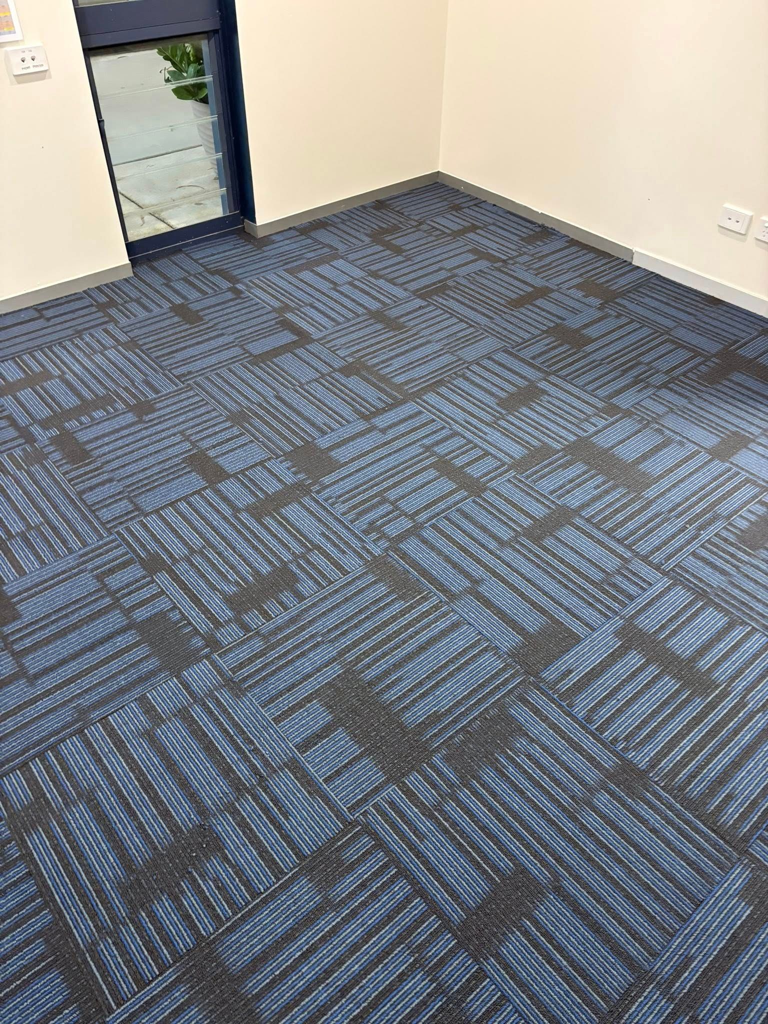 Room with blue and gray patterned carpet, beige walls, and a doorway — Mareeba Floor Covering Centre in Cassowary Coast, QLD