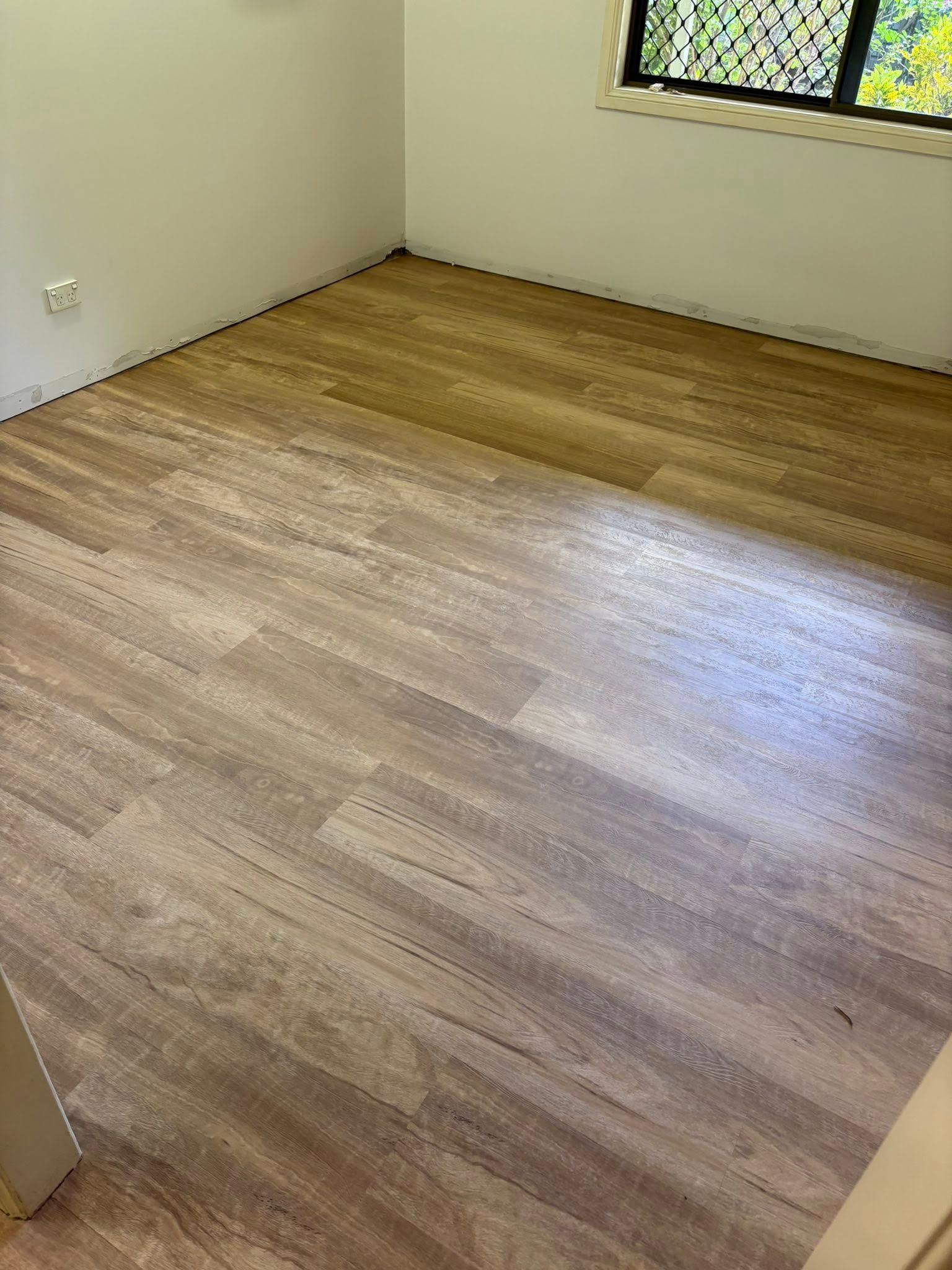 Empty Room With Light Wood-look Flooring — Mareeba Floor Covering Centre in Mareeba, QLD