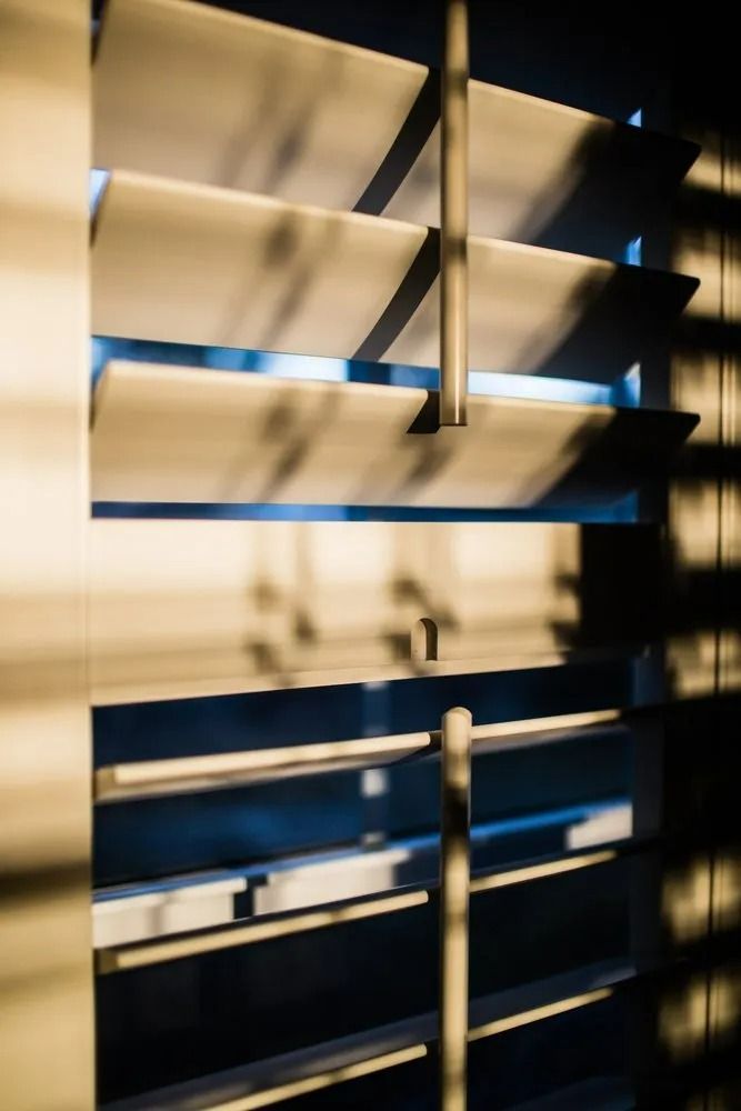 Wooden Window Blinds With Warm Sunlight Casting Shadows — Mareeba Floor Covering Centre in Port Douglas, QLD