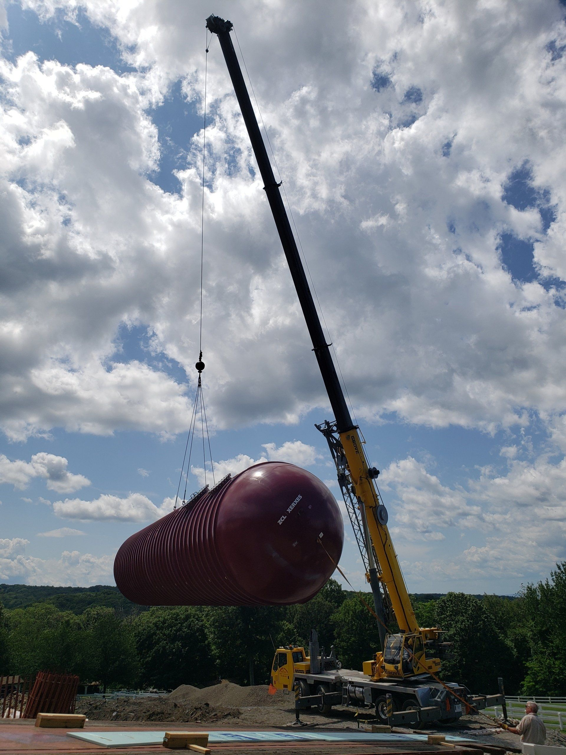 A large purple object is being lifted by a crane