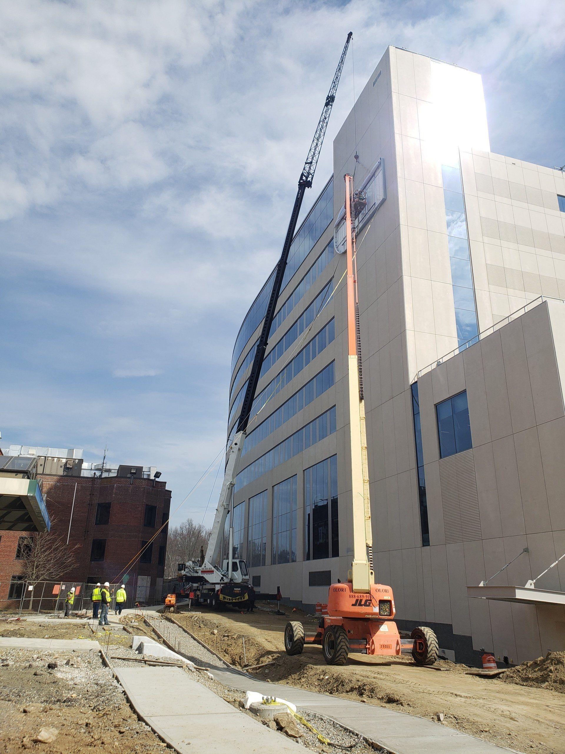 A large building under construction with a crane in front of it