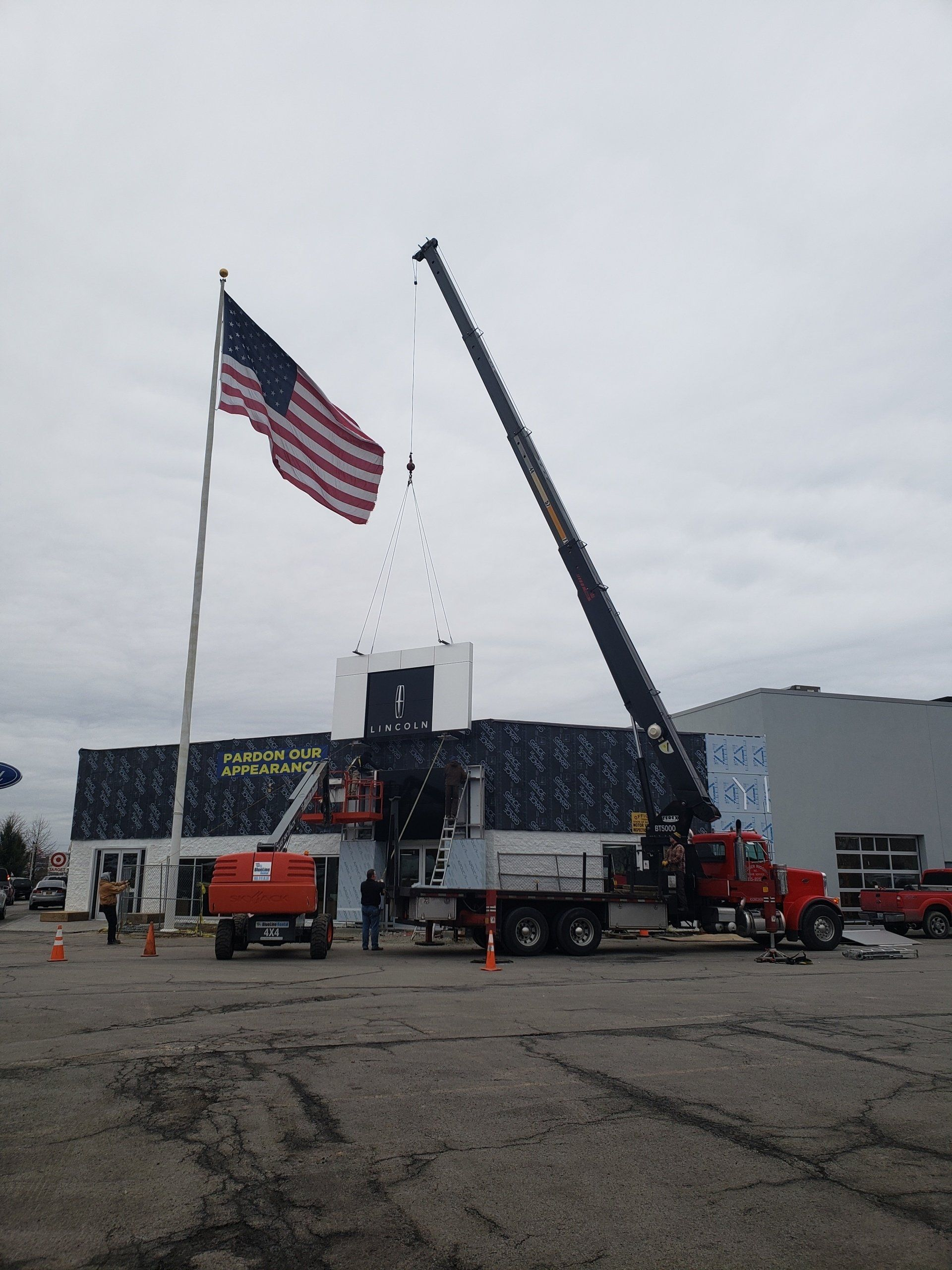 A large american flag is flying in front of a large building