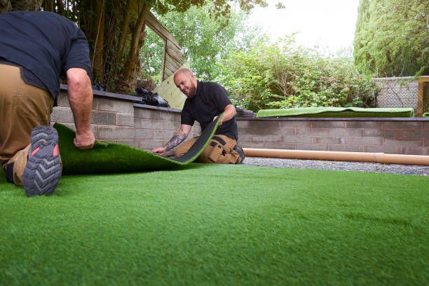 Workers unrolling fake lawn turf