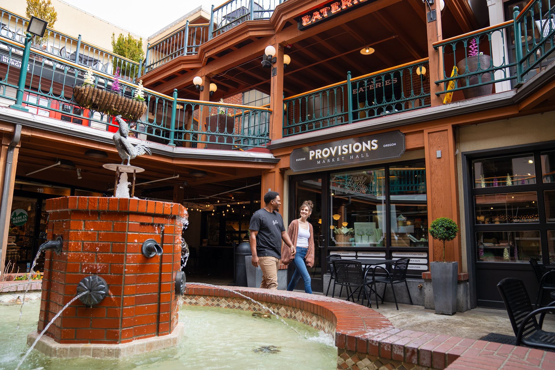 A couple strolling in the Market core near the infamous water fountain with Swifty on top on a beautiful summer day