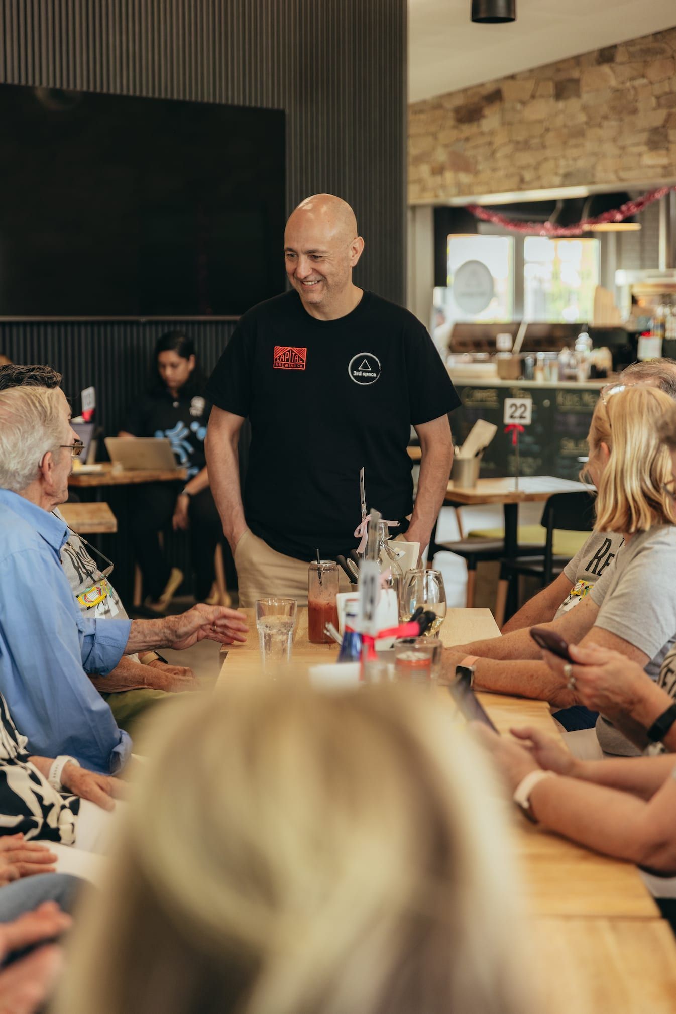 A group of people are sitting at tables in a restaurant eating pizza.