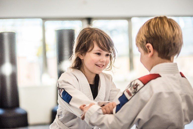 Two young kids learning and training Brazilian Jiu Jitsu