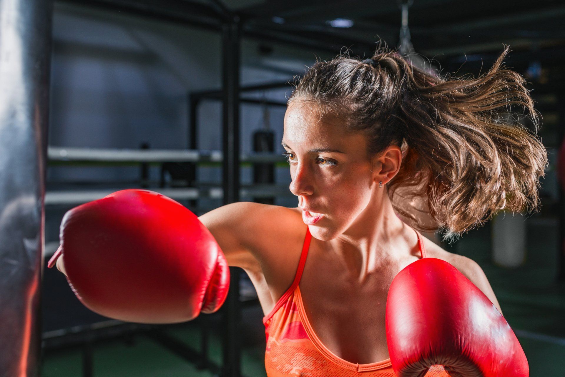 Professional lady boxer throwing punches for training