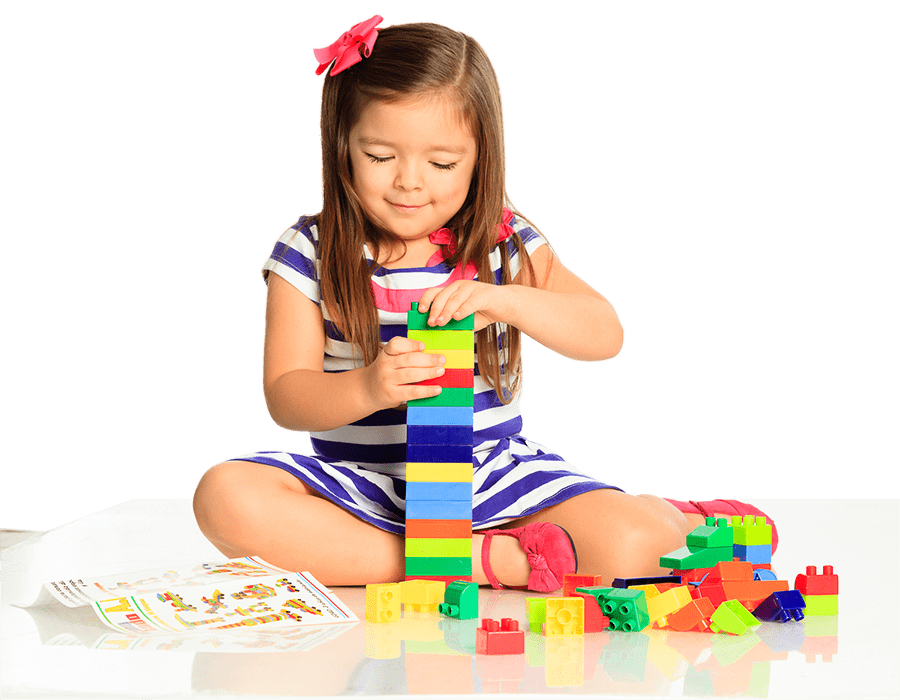 Una niña está sentada en el suelo jugando con bloques de Lego.