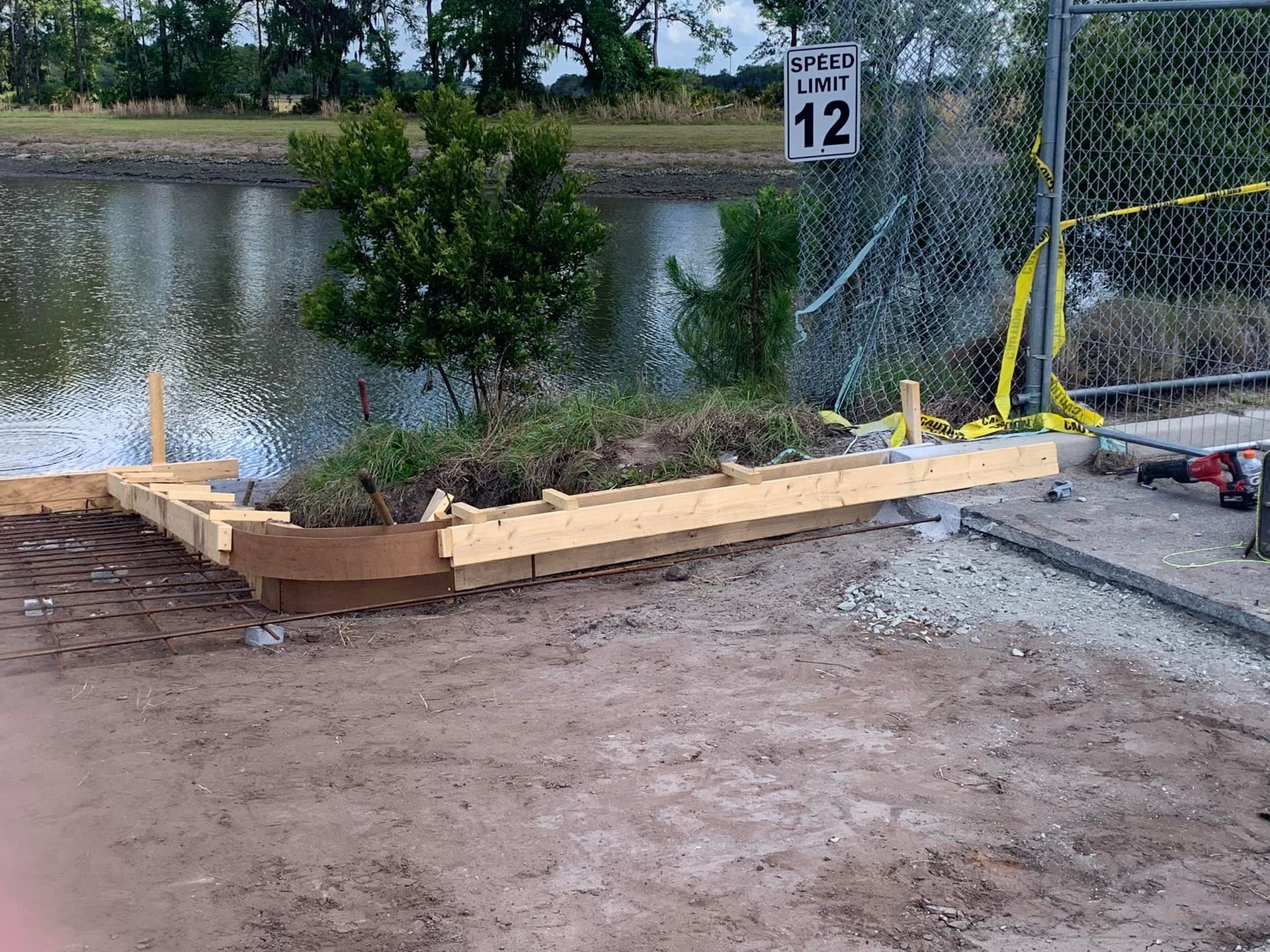 A wooden fence is being built next to a body of water.