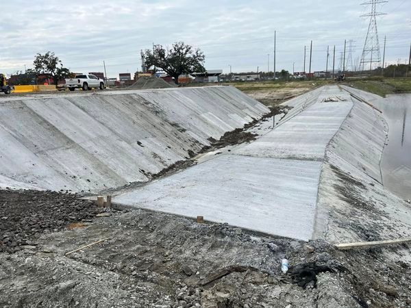 A concrete wall is being built next to a body of water.
