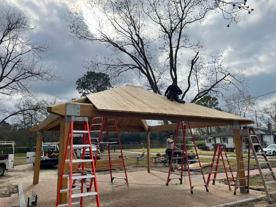 A man is working on the roof of a wooden structure.
