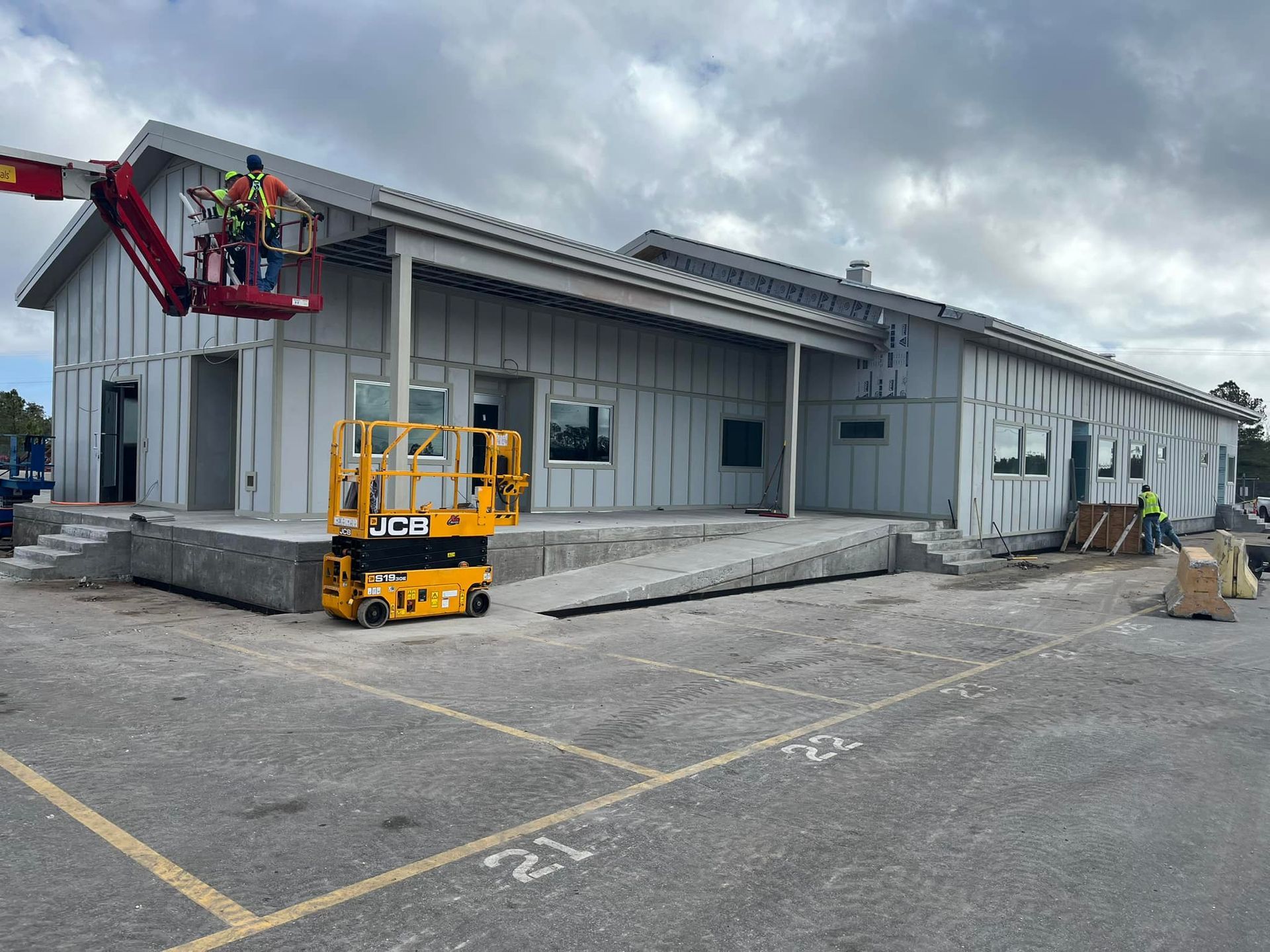 A large building is being built in a parking lot.