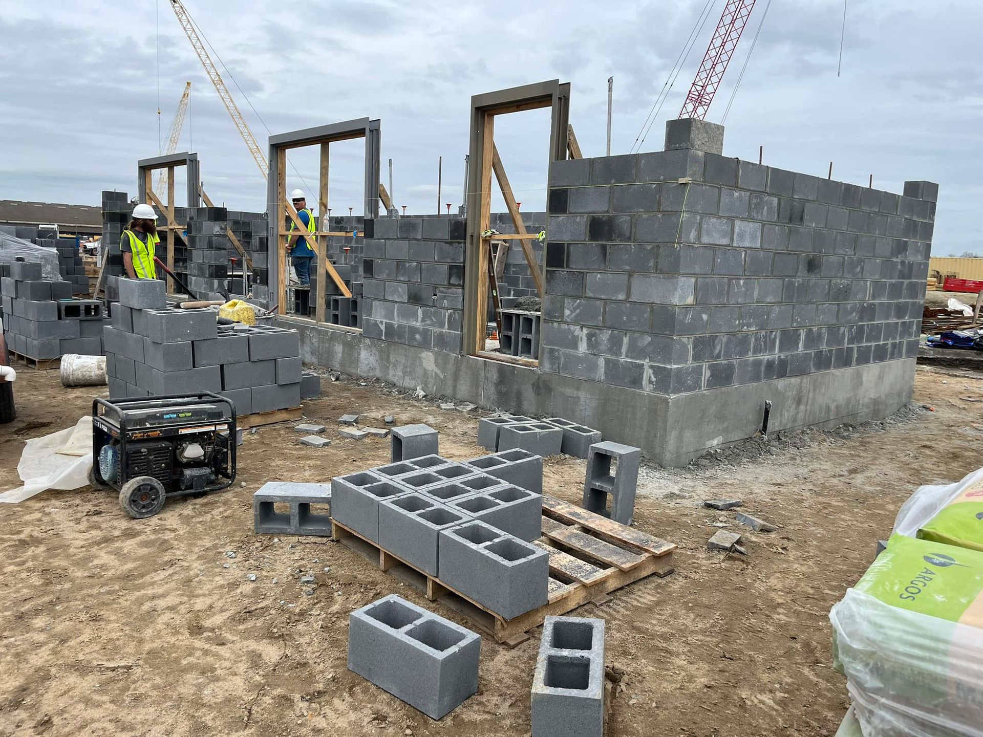 A building is being built with bricks and a crane in the background.