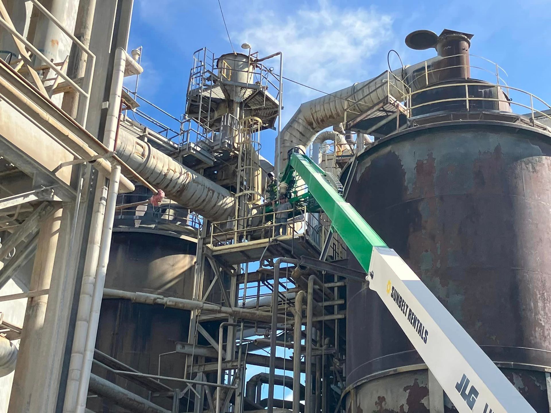 A crane is working on a large building in a factory.