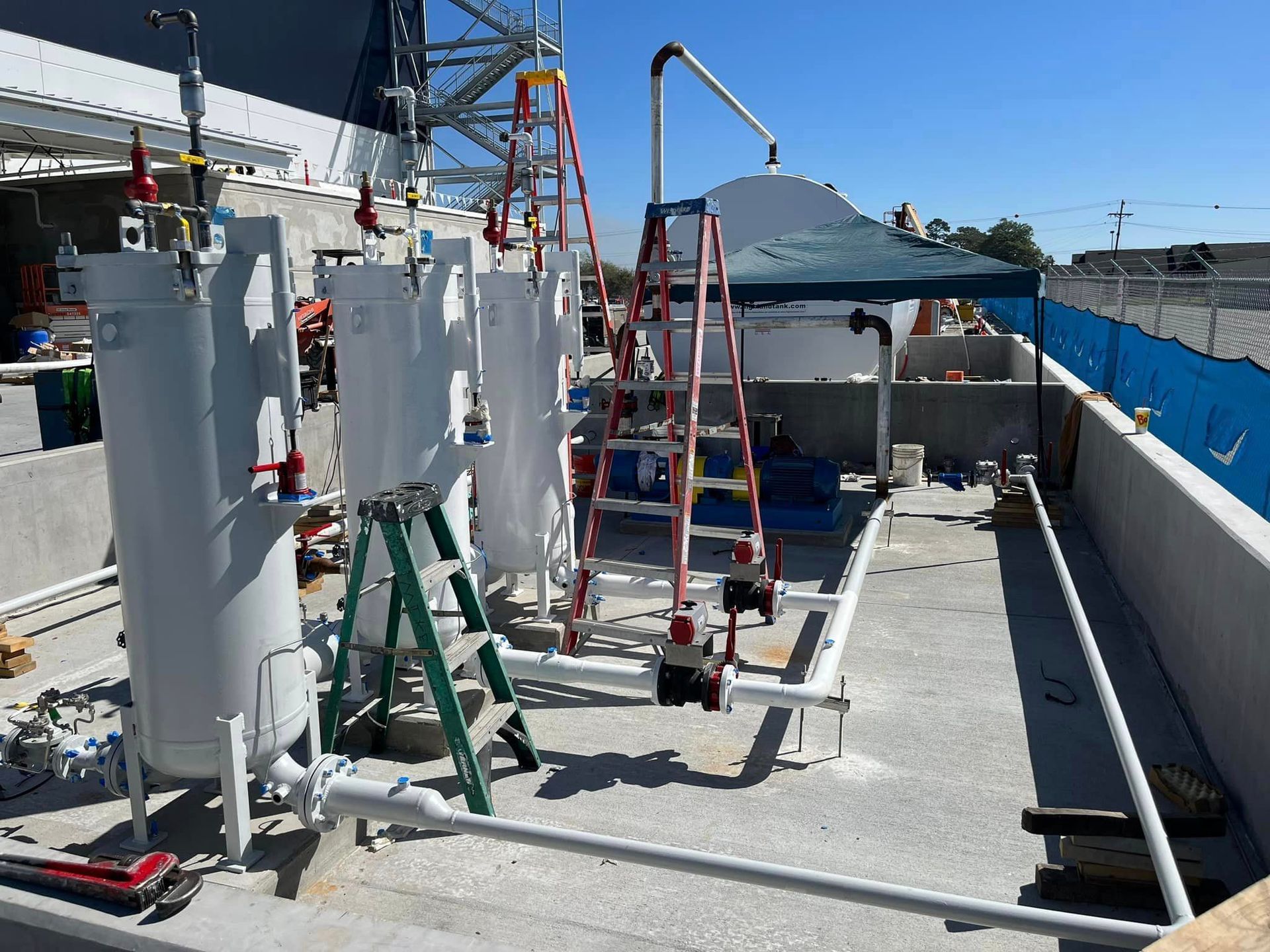 A ladder is sitting next to a bunch of pipes