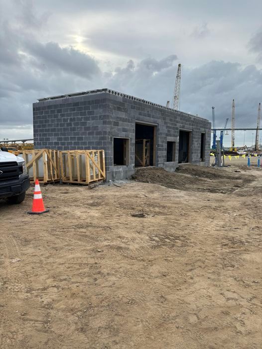 A truck is parked in front of a building under construction.