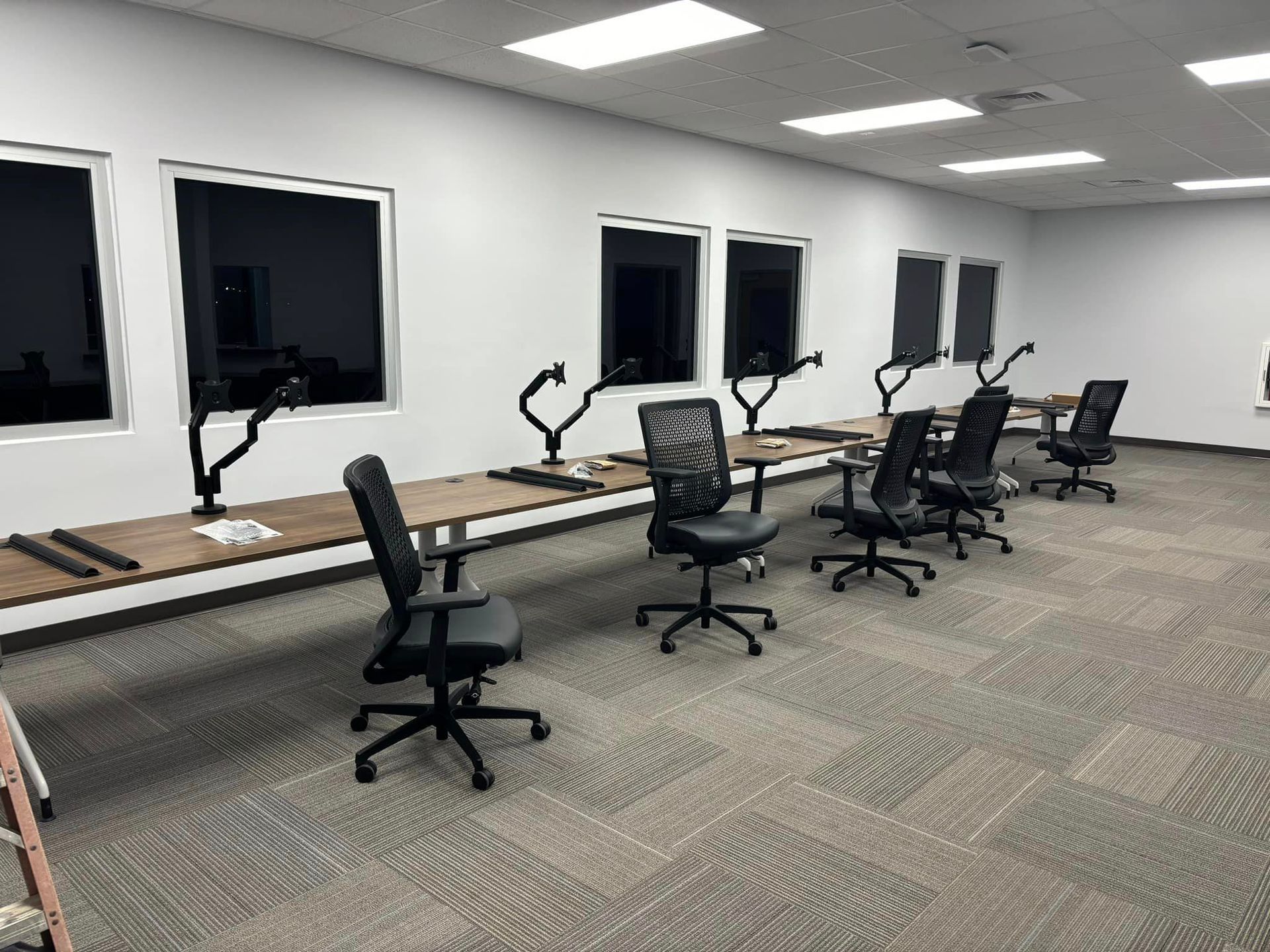 A room with tables and chairs in it and a lot of windows.