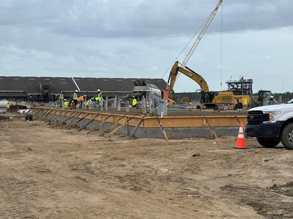 A construction site with a truck and a crane in the background.