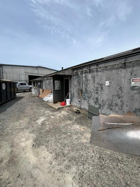 A large building with a lot of trash on the ground in front of it.