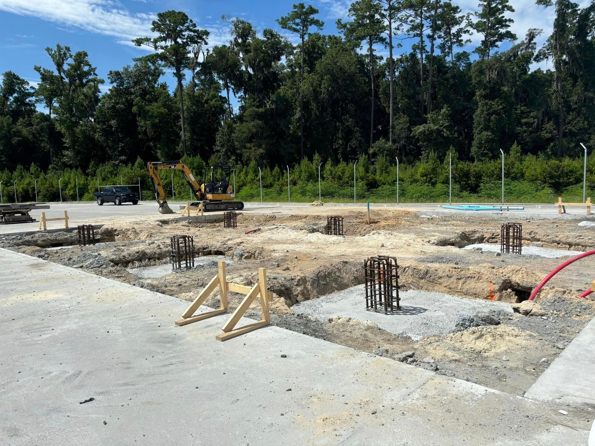 A construction site with a lot of dirt and trees in the background