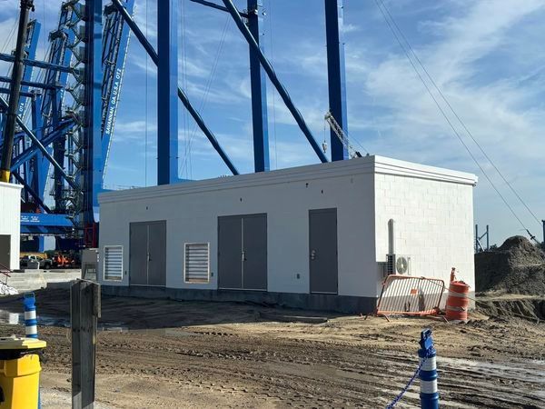 A construction site with a large blue crane in the background.