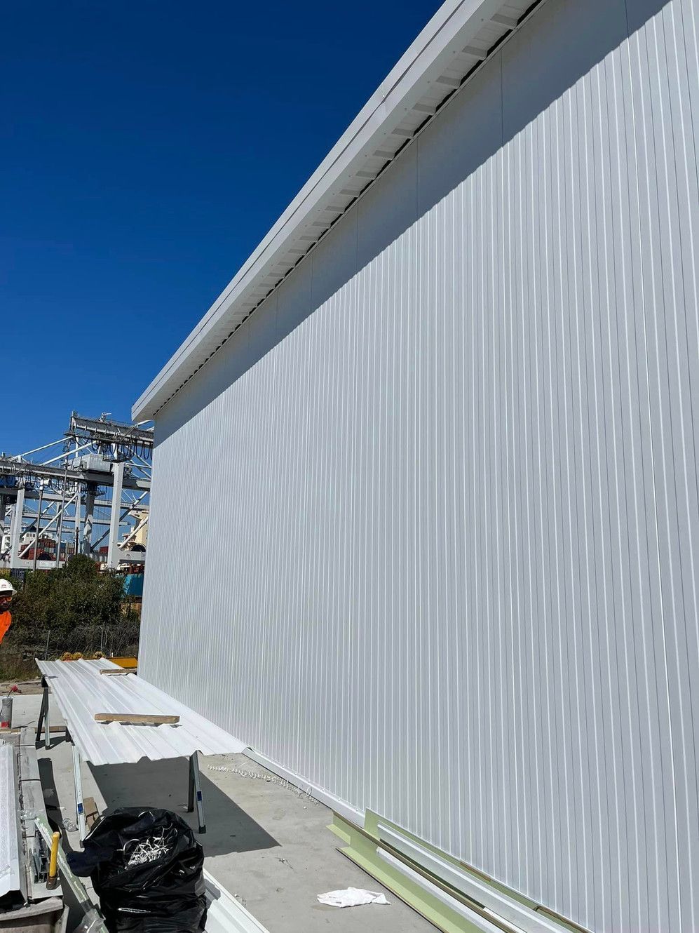 A large white building with a blue sky in the background is being built.