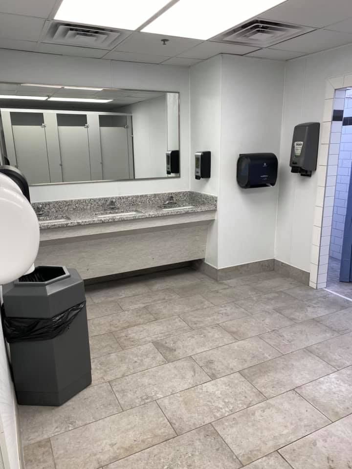 There is a trash can in the middle of the bathroom.