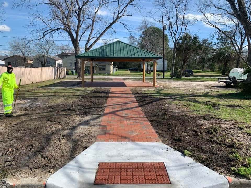A man in a yellow jumpsuit is walking down a brick walkway.