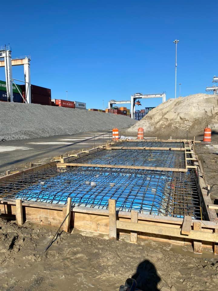 A large concrete slab is being poured in a construction site.