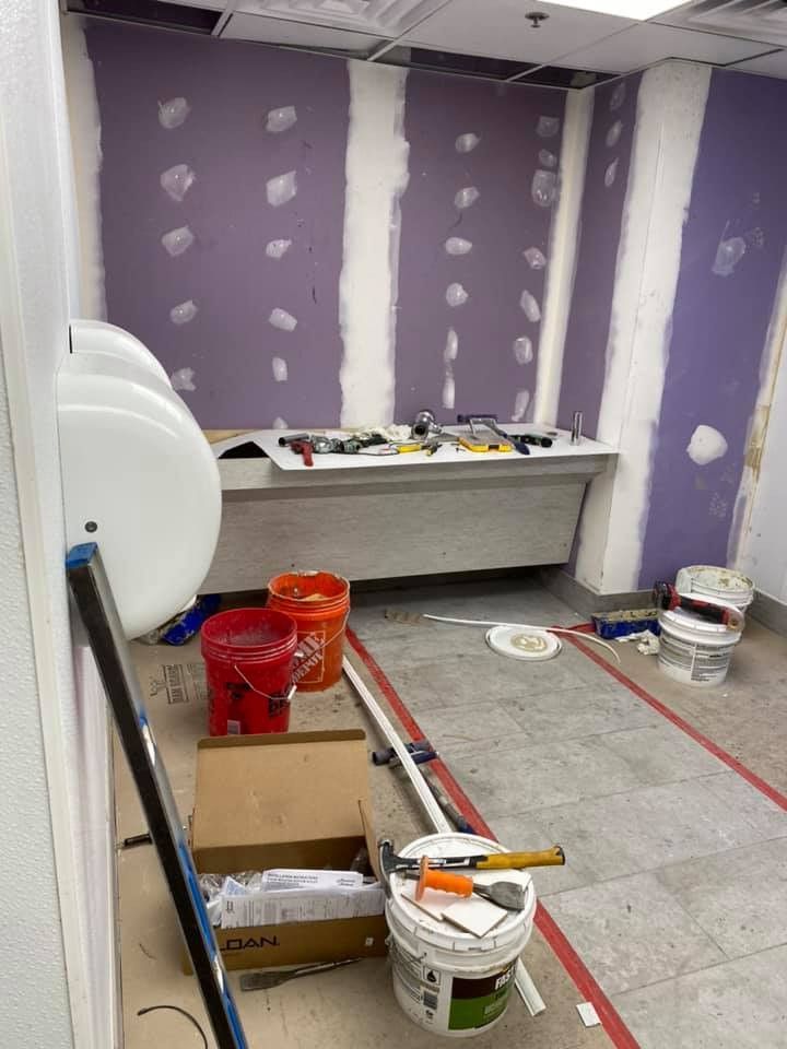 A room with buckets of paint and tools on the floor.