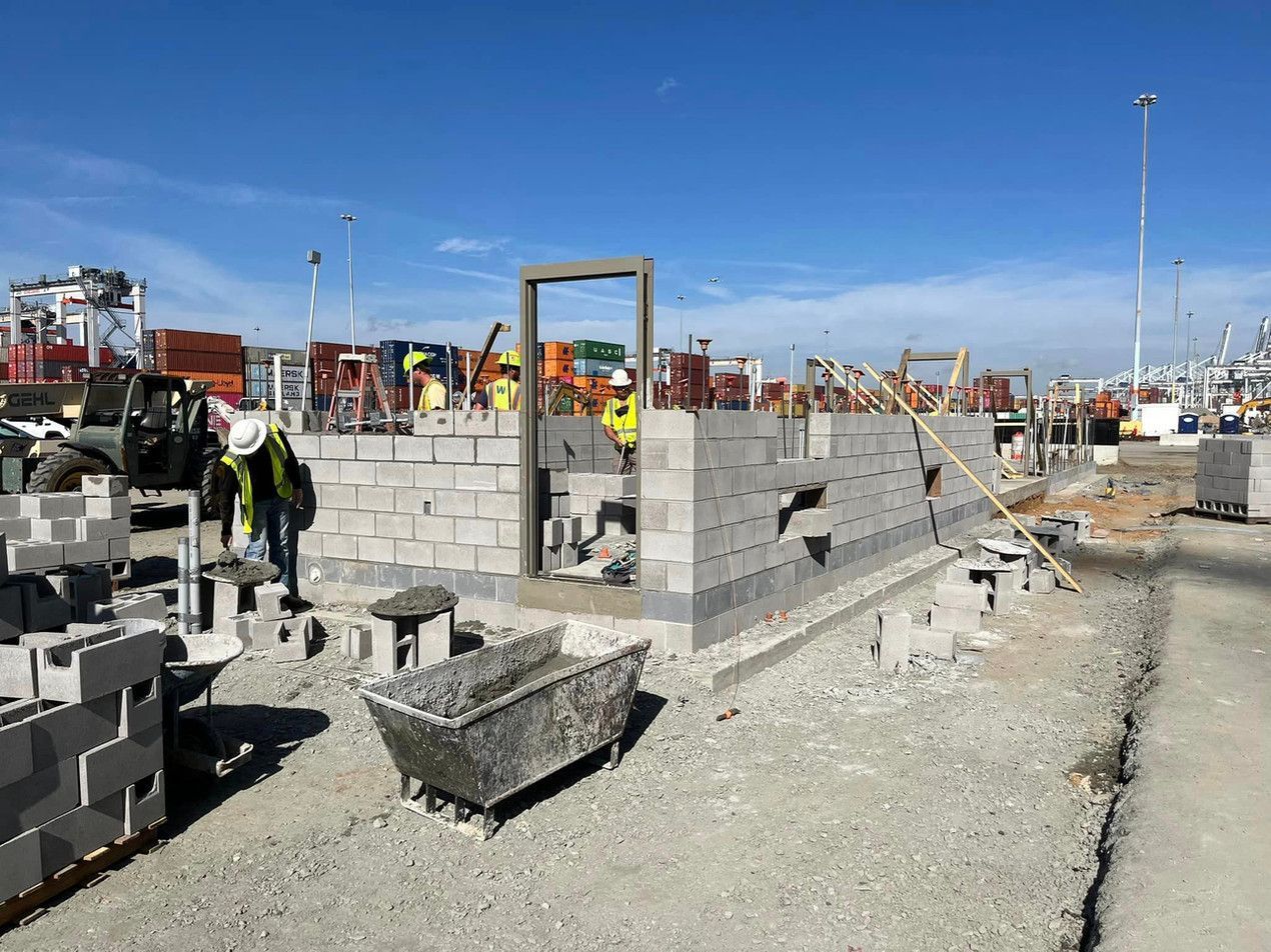 A group of construction workers are working on a building on a construction site.