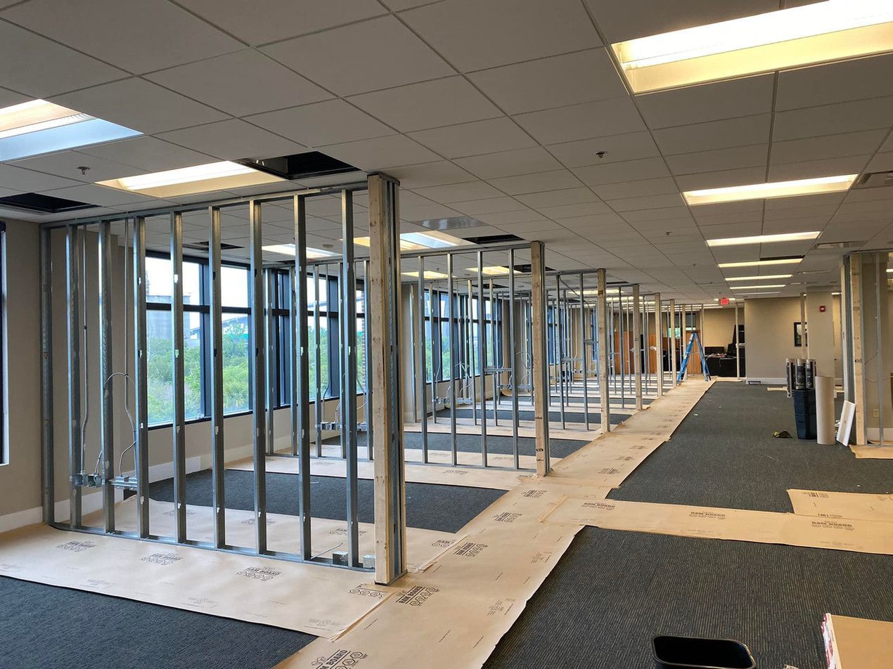 A large room with a lot of windows is being remodeled.