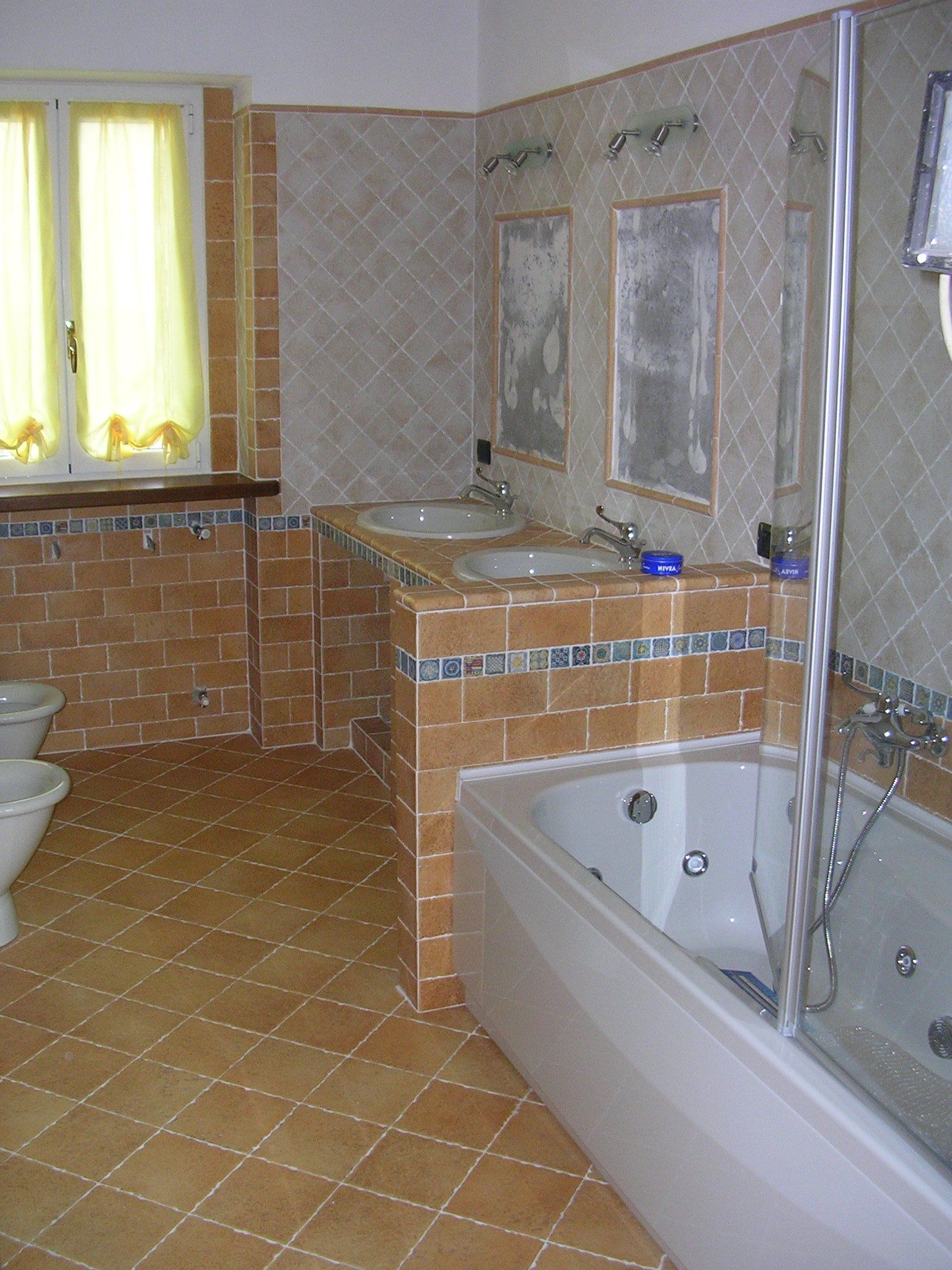 Ampia stanza da bagno con pareti rivestite di piastrelle di ceramica