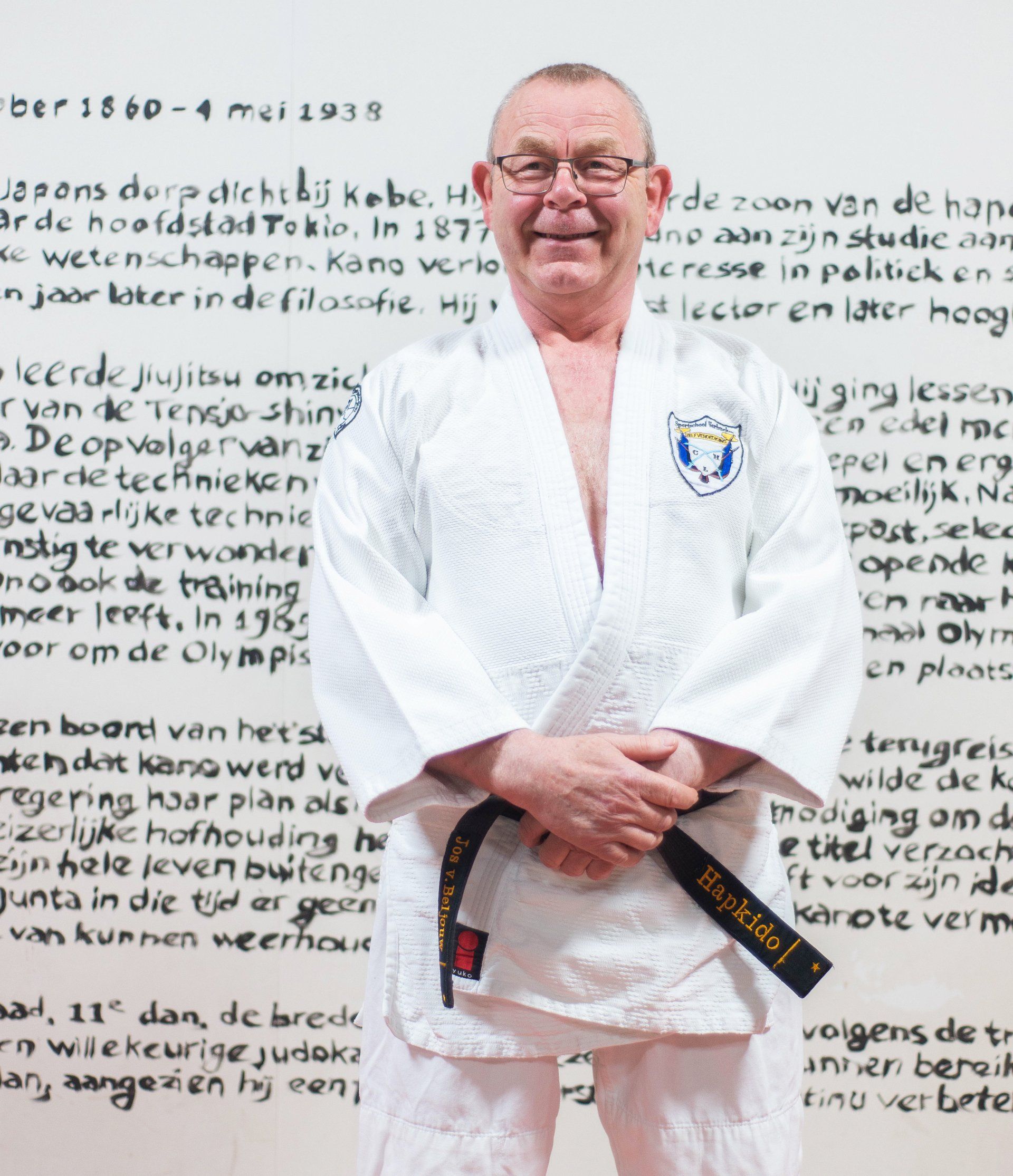 Een man in een wit karate-uniform met een zwarte band