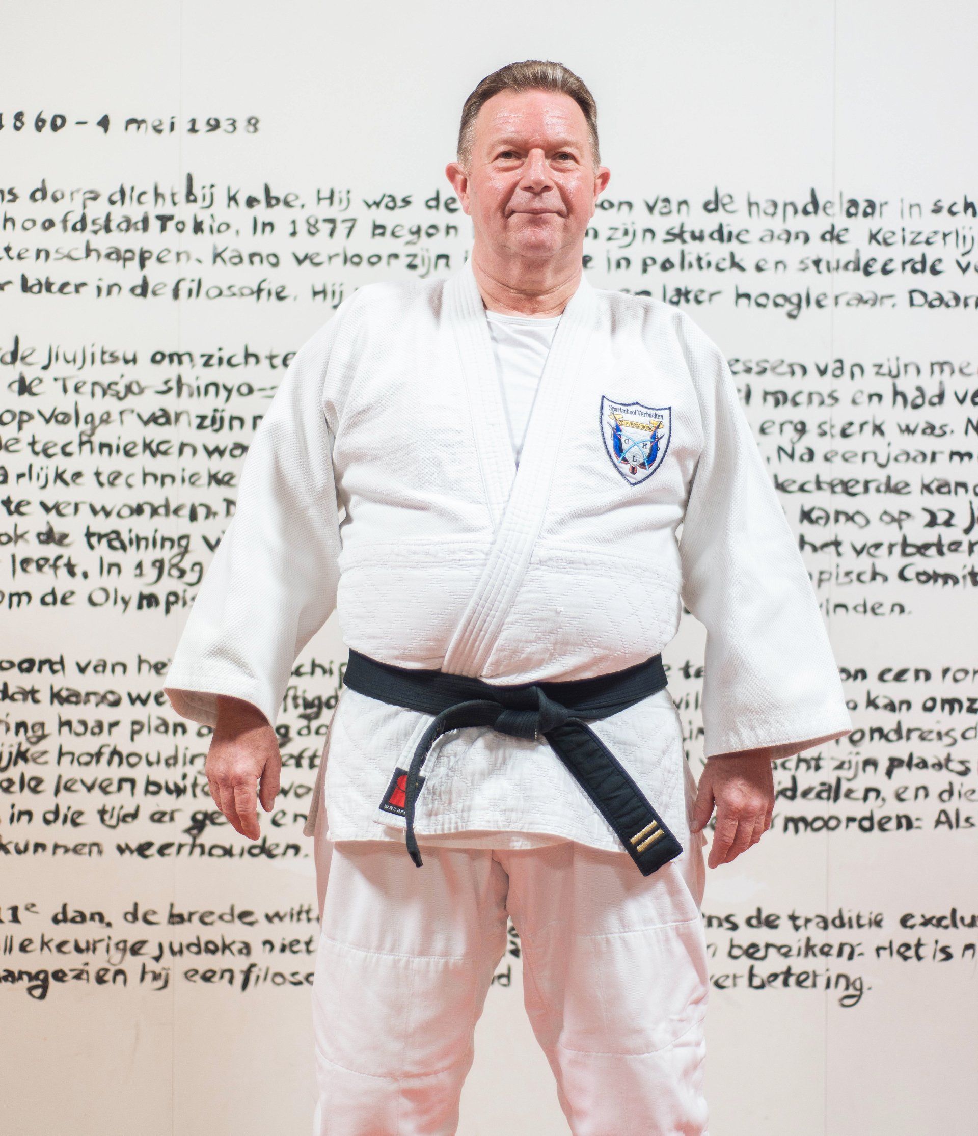 Een man in een wit karate-uniform met een zwarte band