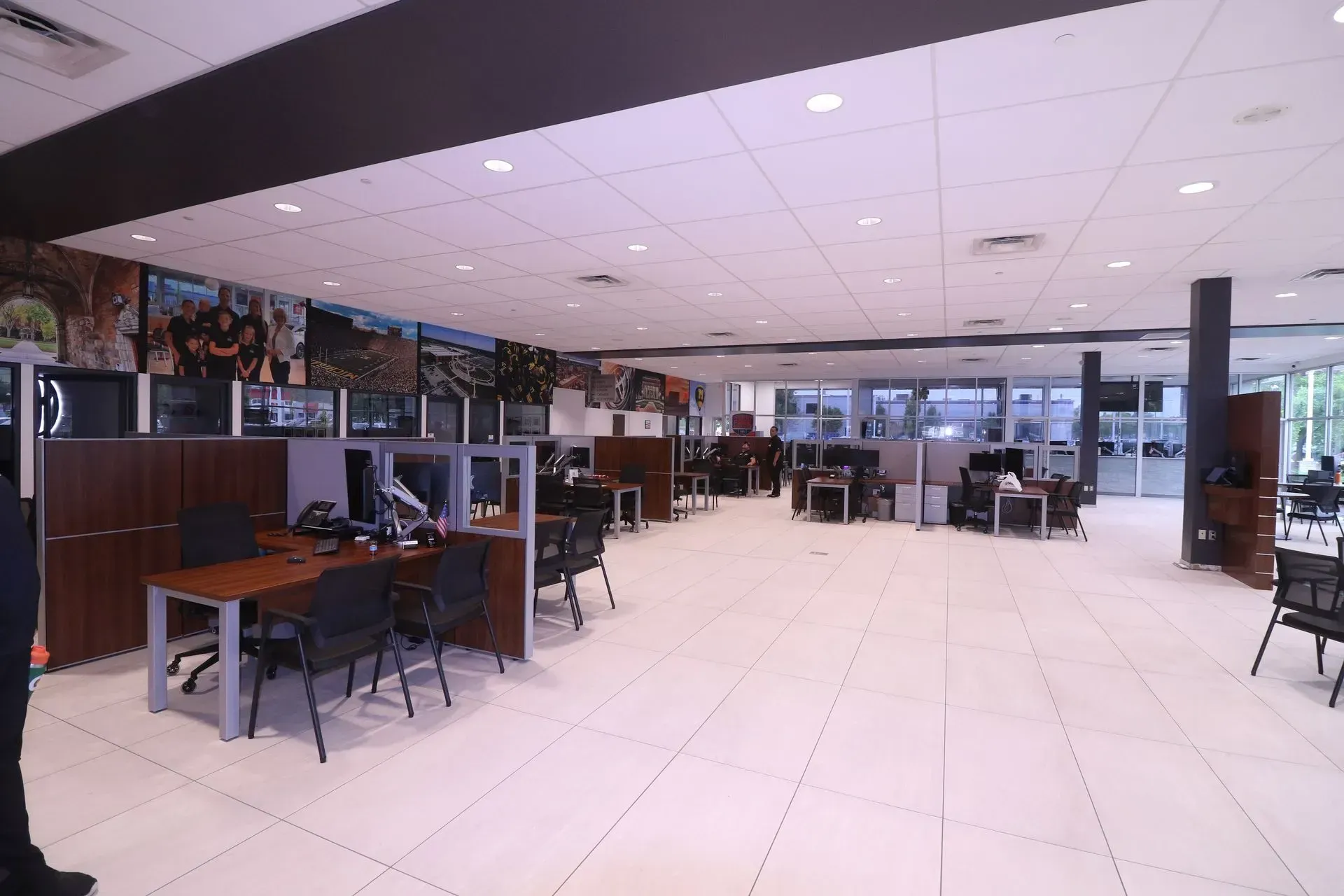 An open-plan office space with cubicles, desks, chairs, and employees working.