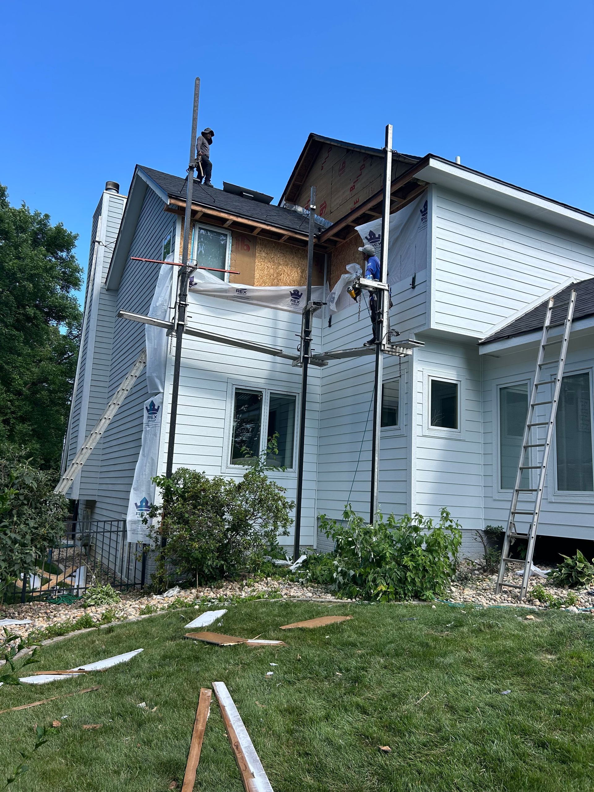 Vinyl siding samples: beige, yellow, and blue wood grain textures.