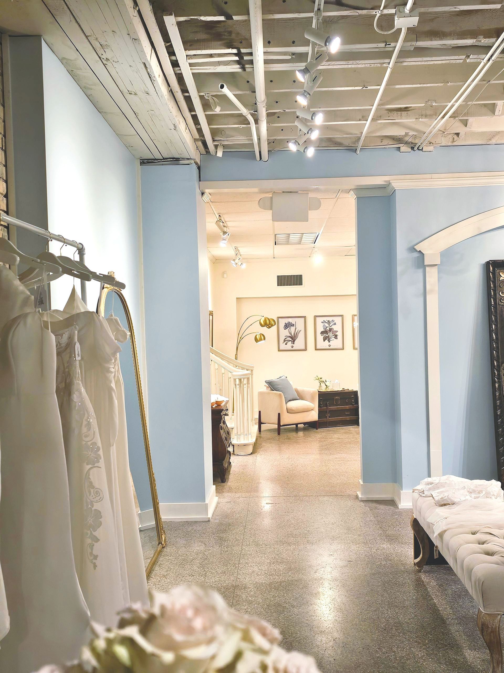 A room with a bunch of dresses hanging on a rack