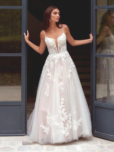 A woman in a wedding dress is standing in front of a door.