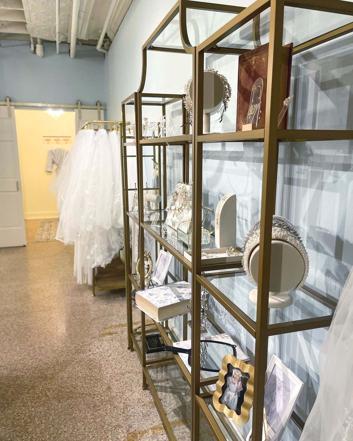 A row of shelves filled with jewelry and dresses in a store.