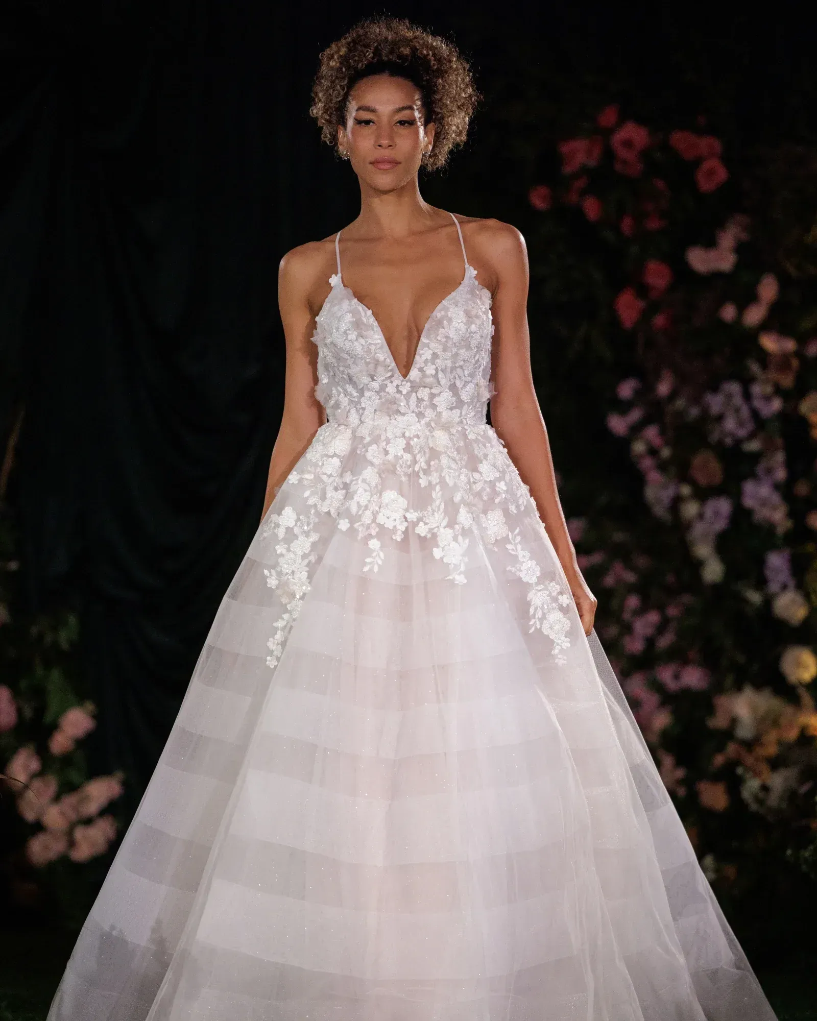 A woman is wearing a white wedding dress with a high slit.