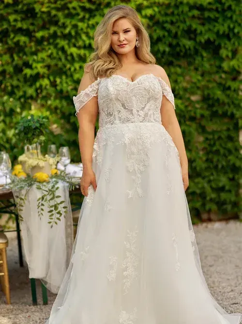 A plus size model is wearing a white wedding dress.