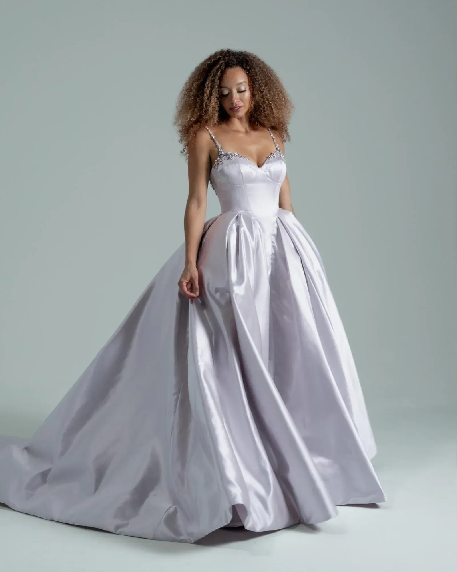 A woman in a white wedding dress is standing in front of a building.